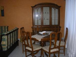 uma sala de jantar com uma mesa de madeira e cadeiras em Terrazza Sul Mare em Gioiosa Marea