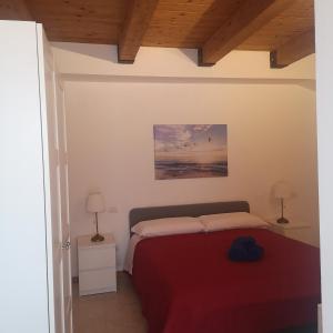 um quarto com uma cama com um cobertor vermelho em La Persiana2 em Ancona