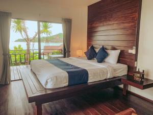 a bedroom with a large bed with a wooden headboard at High Life Bungalow in Haad Yao