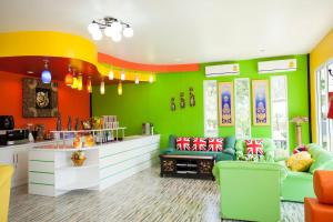 - un salon avec des murs verts et orange dans l'établissement Baanraisooksangchan, à Kaeng Krachan
