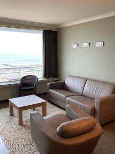 - un salon avec un canapé et une table dans l'établissement 'Maastricht' - Cosy Studio with Spectacular Seaview, à Ostende