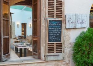 a restaurant with a sign on the side of a building at Alcudia Petit - Turismo de Interior in Alcudia