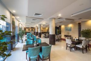 a dining room with tables and chairs and a lobby at Myrtle Al Shohadaa Serviced Apartments in Riyadh
