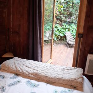 a bedroom with a bed and a sliding glass door at Foudres du Chêne du Py in Villié-Morgon