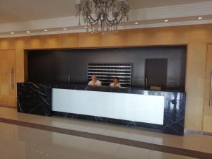 two people standing in a reception desk in a lobby at ESCAPADA a PdE !! in Punta del Este