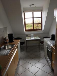 a small kitchen with a table and a window at Zwischen den Feldern in Brebel