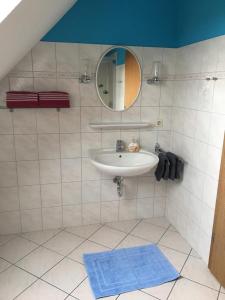 La salle de bains est pourvue d'un lavabo et d'un miroir. dans l'établissement Zwischen den Feldern, à Brebel