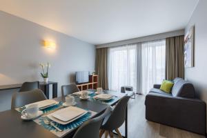 - un salon avec une table et un canapé dans l'établissement Thon Hotel Residence Parnasse Aparthotel, à Bruxelles
