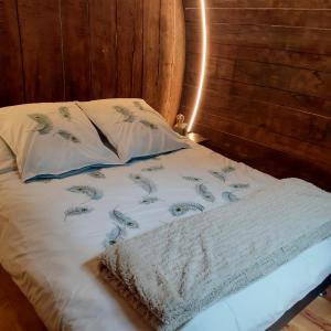 a bed with a white comforter and two pillows at Foudres du Chêne du Py in Villié-Morgon