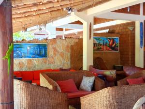 Habitación con sillas de mimbre y sofá rojo. en Hotel Lakana Ramena, en Antsiranana