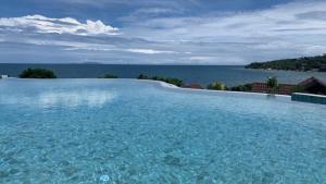 a large swimming pool with a view of the ocean at High Life Bungalow in Haad Yao