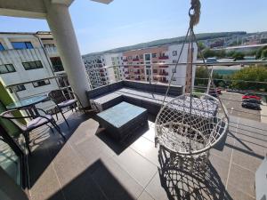 - un balcon avec une balançoire et un banc dans un bâtiment dans l'établissement Apartament Diana, à Târgu-Mureş