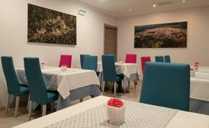 un restaurante con mesas y sillas y una pintura en la pared en Hotel Avenida Plaza, en Alzira