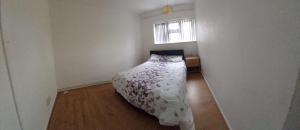 a bedroom with a bed in a room with a window at Relaxing double bedroom in Romford