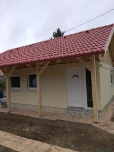 ein kleines Haus mit rotem Dach in der Unterkunft Jómadarak Nyaralója in Veresegyház