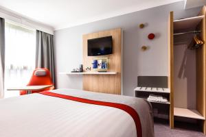 a hotel room with a bed and a tv at Holiday Inn Express London Stansted Airport, an IHG Hotel in Stansted Mountfitchet