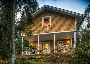 ein Haus im Wald mit einer Veranda in der Unterkunft Juhlamenot Oy in Söderkulla