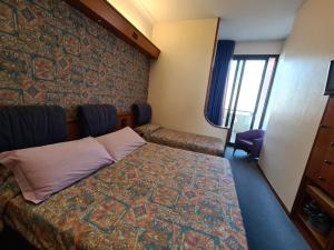 um quarto de hotel com uma cama e uma parede de pedra em Hotel Sabra em Senigallia