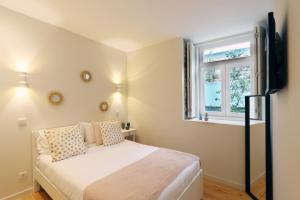een kleine slaapkamer met een bed en een raam bij HM - Segredo do Porto in Porto