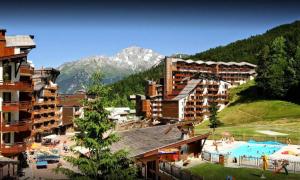 a resort with a swimming pool and a mountain at Residence Le Christiana - maeva Home in La Tania