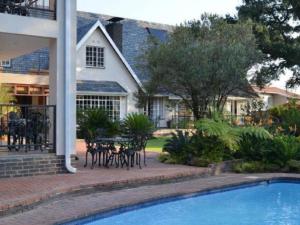 a house with a swimming pool in front of a house at Gallo Manor Executive Bed & Breakfast in Johannesburg