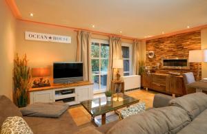 een woonkamer met een bank en een tv bij Robben Hüs in Westerland