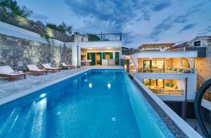 a swimming pool in front of a house at Luxury Residence Mladenka in Jesenice +56 photos