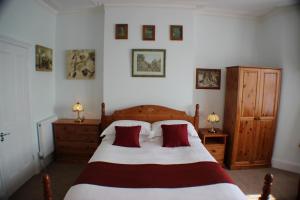 a bedroom with a large bed with red pillows at Filton Guest House in Bristol