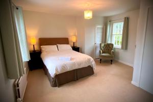 - une chambre avec un grand lit et une chaise dans l'établissement Peaceful 2 bedroom granite country dower house, à La Villaise