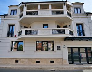 a large white building with windows at Grant Boutique Hotel in Arad
