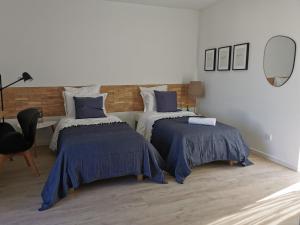 a bedroom with two beds with blue comforters at Casa das Portas in Azinhaga +70 photos