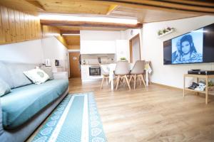 a bedroom with a bed and a dining room at La Mansarda di Emma in Pinzolo