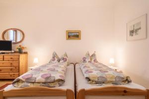 une chambre avec deux lits jumeaux et une commode dans l'établissement Obstgarten, à Lindau