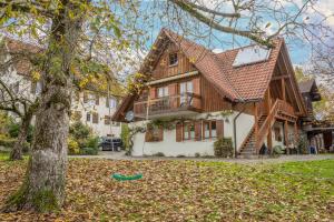 une maison avec un arbre devant dans l'établissement Obstgarten, à Lindau