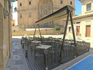 a group of tables and chairs in a courtyard with a building at HOTEL GUADALOPE in Alcañiz
