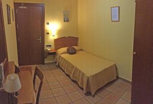 a small bedroom with a bed in a room at HOTEL GUADALOPE in Alcañiz