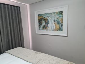 a bedroom with a picture on the wall and a bed at Villa Casa Lifestyle in Nelspruit