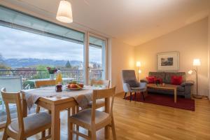 ein Wohnzimmer mit einem Tisch und Stühlen sowie einem großen Fenster in der Unterkunft Pfirsichblüte in Auf der Mauer