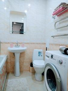 a bathroom with a toilet and a washing machine in it at Студия ЖК Лондон in Syktyvkar