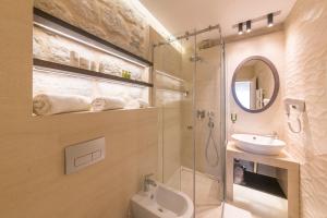 a bathroom with a sink and a toilet and a mirror at Heritage Hotel Leon Coronato in Perast