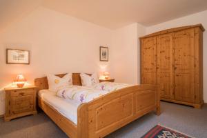 a bedroom with a wooden bed and a wooden cabinet at Apfelblüte in Lindau