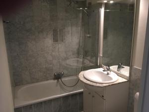 La salle de bains est pourvue d'un lavabo, d'une douche et d'une baignoire. dans l'établissement prachtige studio met havenzicht, à Ostende