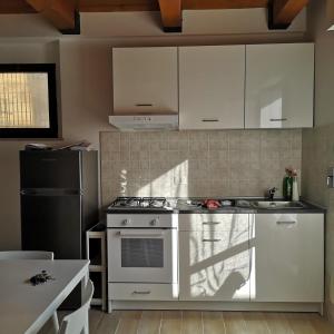 uma cozinha com electrodomésticos brancos e um frigorífico preto em La Persiana2 em Ancona