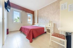 um quarto com uma cama, uma secretária e uma janela em Gold Hotel em Bordighera