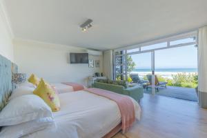 a bedroom with two beds and a view of the ocean at Dune Beach House in Wilderness