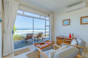 a living room with a view of the ocean at Dune Beach House in Wilderness