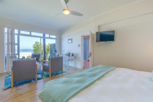 a bedroom with a large bed with a flat screen tv at Dune Beach House in Wilderness