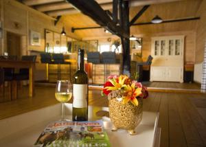 a bottle of wine and a vase with flowers on a table at Bed & Breakfast De Stippelberg in Rips