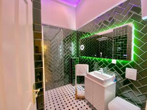 a bathroom with a green and black tiled wall at Hevals Palace in Berlin