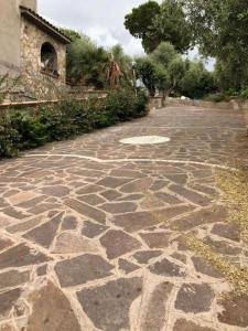 a stone walkway in a yard with a building at La casa tra gli ulivi di Fonte Nuova 1 in Fonte Nuova